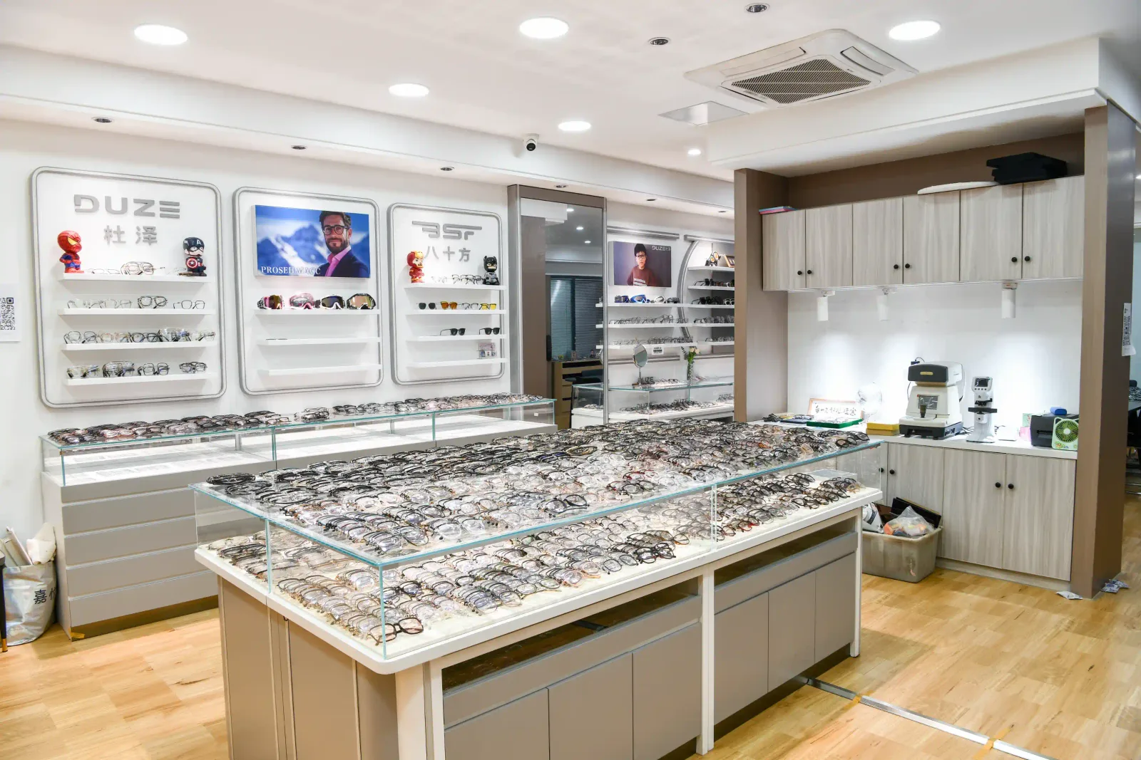 Glass display island of eyewear samples beside the HAO Eyewear brand wall