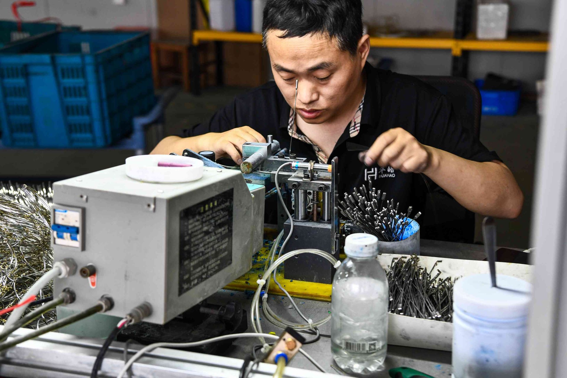 HAO Eyewear branded uniform worker performing precision metal frame welding